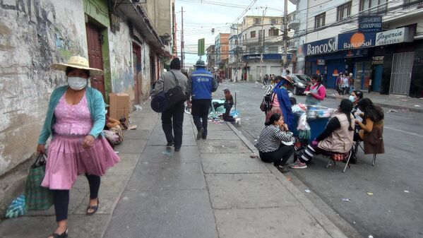 17:04. Resignadas por la ausencia de clientes, las señoras que tienen sus puestos en el mercado de La Cancha (el más grande de Cochabamba) cerraron sus comercios y se reunieron en torno a la casera que les vende comida, a manera de despedir la semana. - Sputnik Mundo