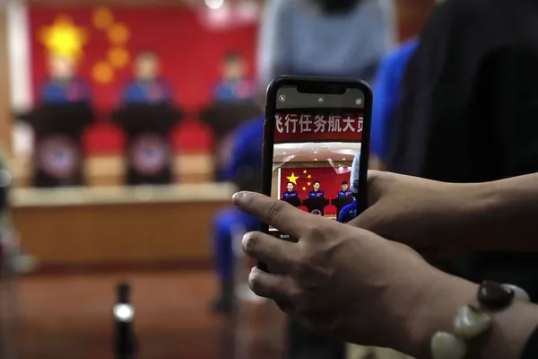 Un periodista fotografía a los taikonautas chinos durante una rueda de prensa en Jiuquan. Un periodista fotografía a los taikonautas chinos durante una rueda de prensa en Jiuquan. - Sputnik Mundo