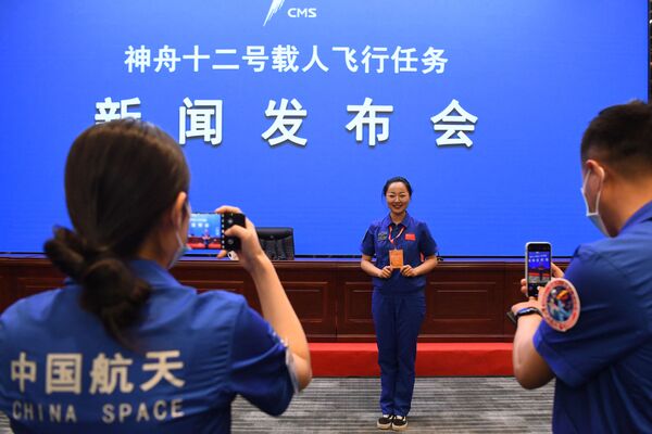 Los empleados del Jiuquan Satellite Launch Center se hacen fotos antes de la rueda de prensa. - Sputnik Mundo