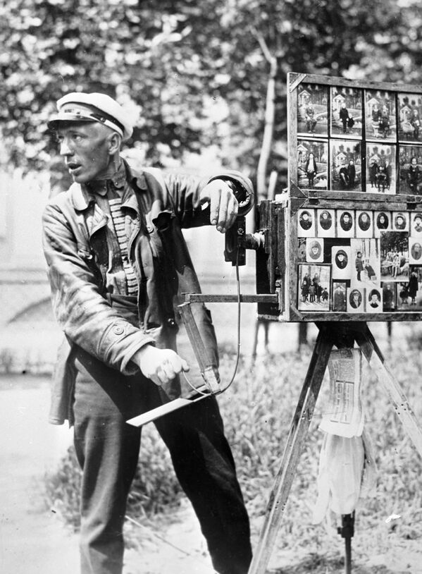 Uno de los prototipos de la película fotográfica moderna contaba con 12 hojas de papel fotosensible y pesaba 15 kilogramos.En la foto: un fotógrafo callejero en 1922.  - Sputnik Mundo