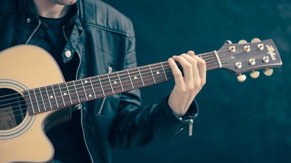 Un chico tocando el guitarra (imagen referencial) - Sputnik Mundo