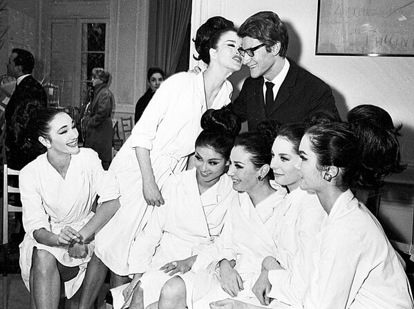 Se considera que el país del día del beso es el Reino Unido porque a finales del siglo XIX se pensó que un beso era digno de tener su propia fiesta. En la foto: Yves Saint Laurent con sus modelos tras el desfile de la colección de primavera en París, Francia, 1964. - Sputnik Mundo