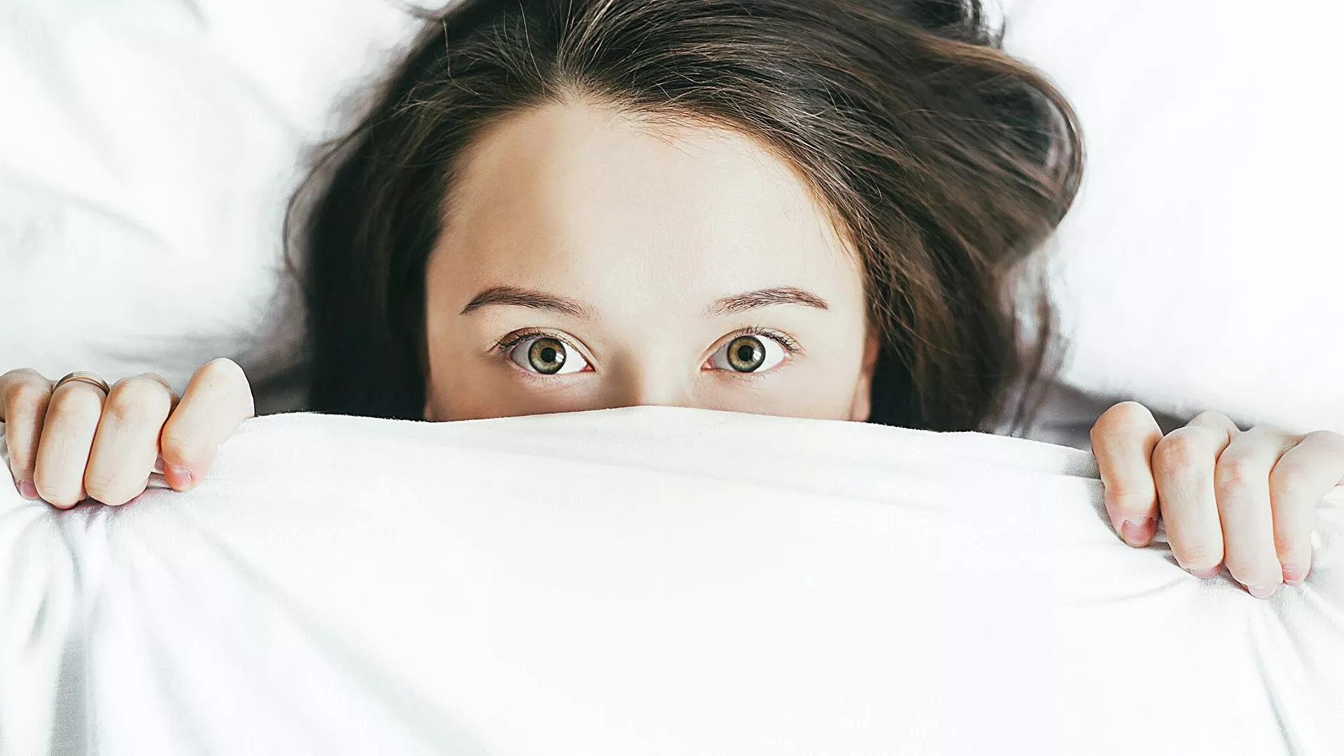 Una mujer debajo de unas sábanas