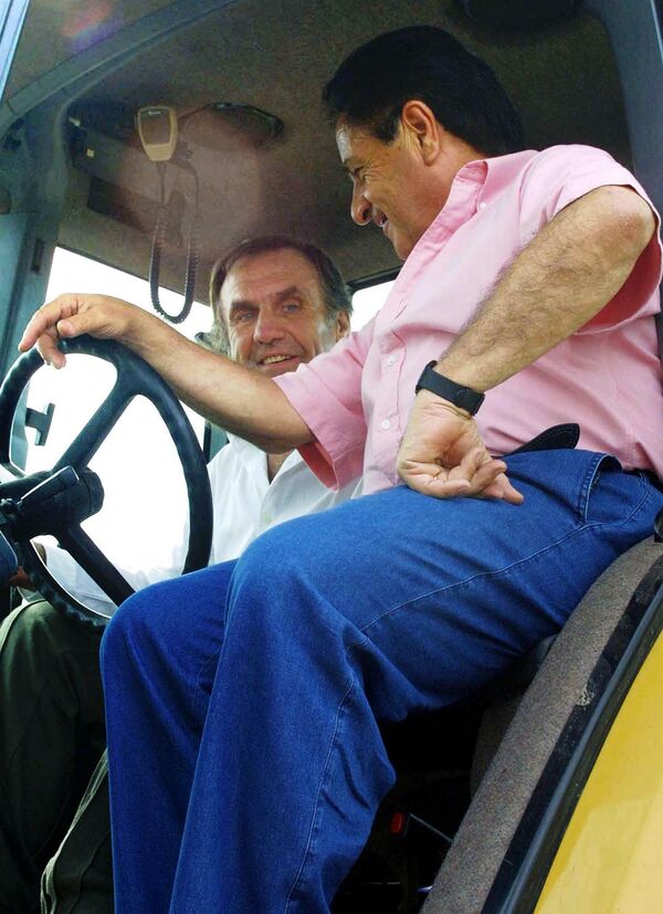 Carlos Reutemann en un tractor junto al expresidente argentino Eduardo Duhalde (2002-2003), conversando sobre una posible candidatura presidencial del expiloto de Fórmula 1 por el Partido Justicialista argentino, para las elecciones del 19 de enero de 2003. Estancia Los Guasunchos, provincia de Santa Fe. 11 julio de 2002.  - Sputnik Mundo