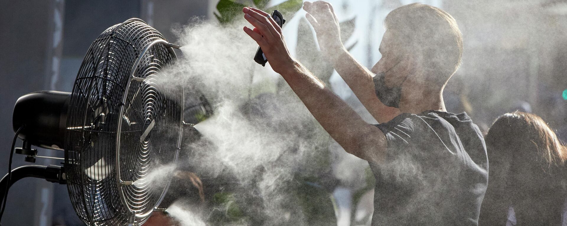 Un chico se refresca del calor con un difusor de vapor de agua de un restaurante de la calle Alcalá en Madrid - Sputnik Mundo, 1920, 10.08.2021