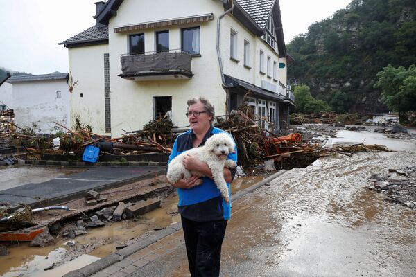 Un hombre con su perro en una calle inundada de Schuld. - Sputnik Mundo