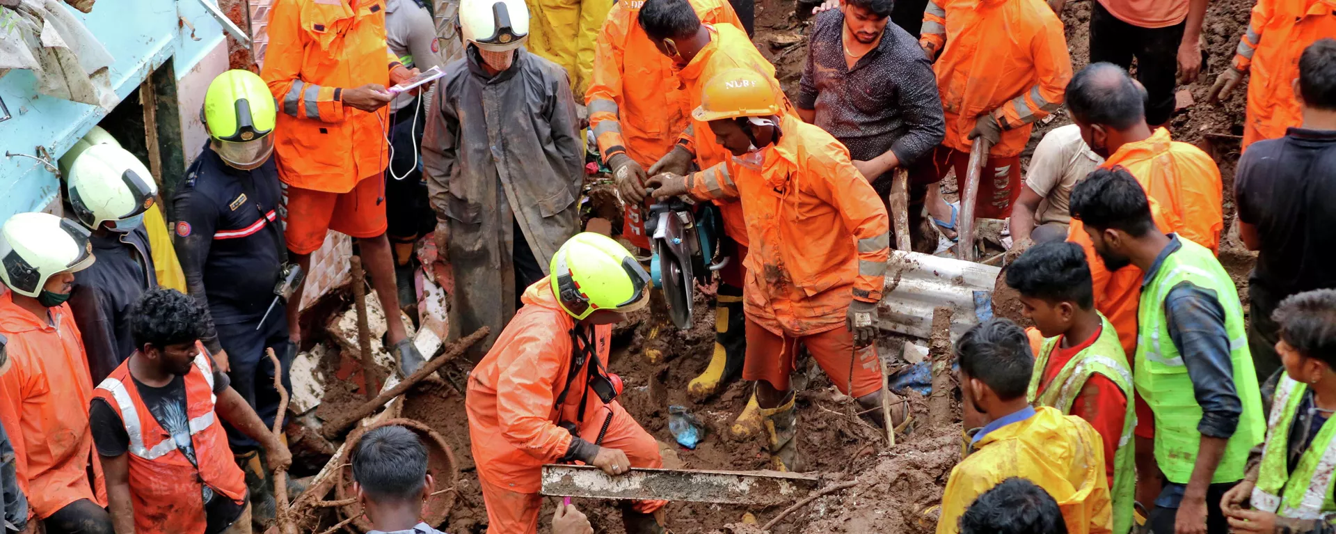 Los trabajadores de rescate retiran escombros mientras buscan sobrevivientes después de que una casa colapsara debido al deslizamiento de tierra causado por fuertes lluvias en Bombay, la India, el 18 de julio Los trabajadores de rescate retiran escombros mientras buscan sobrevivientes después de que una casa colapsara debido al deslizamiento de tierra causado por fuertes lluvias en Bombay, la India, el 18 de julio - Sputnik Mundo, 1920, 18.07.2021