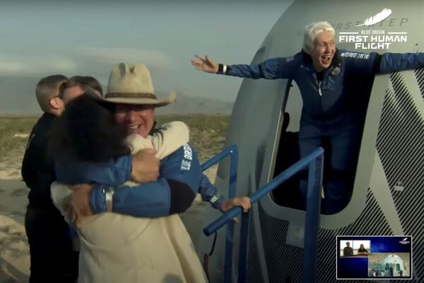 Participante de la primera misión turística suborbital tripulada de Blue Origin, el multimillonario Jeff Bezos y la astronauta de 82 años Wally Funk salen de una cápsula espacial tras aterrizar en el desierto de Texas, Estados Unidos. - Sputnik Mundo