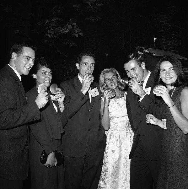 Durante la Primera Guerra Mundial, la hamburguesa tuvo que cambiar de nombre durante un tiempo debido al sentimiento general antialemán. Adoptó entonces el nombre de Salisbury steak. En la foto: el senador Claiborne Pell y su esposa se comen unas hamburguesas durante un picnic con estudiantes universitarios en el jardín de su casa en 1963. - Sputnik Mundo