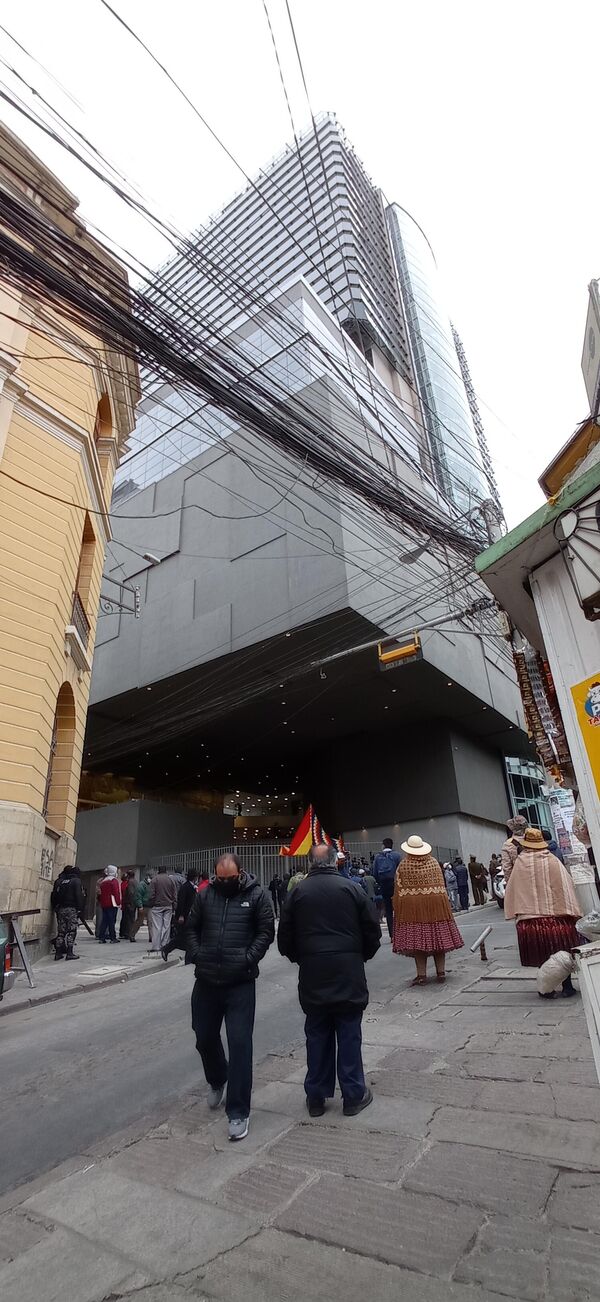 El enorme cubo negro que ya es parte del paisaje paceño coexiste con construcciones centenarias -muchas de las cuales están derruidas- y con la red de teleféricos, que dan un toque futurista a la ciudad. La elegancia posmoderna y ancestral de la nueva Asamblea contrasta con una ciudad plagada por el tráfico vehicular, los cables y un sinfín de obstáculos para las y los peatones - Sputnik Mundo