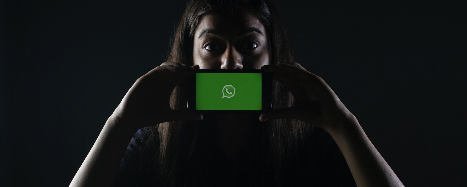 Una persona sostiene un móvil con el logotipo de WhatsApp - Sputnik Mundo, 1920, 05.08.2021