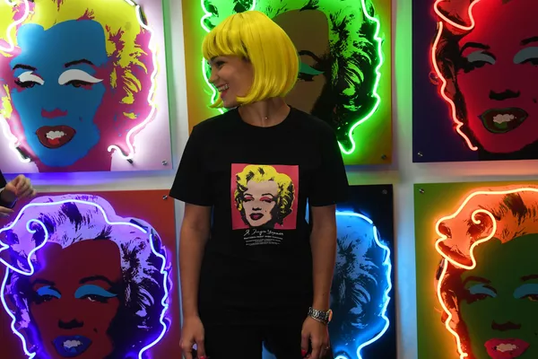 Pese a su controvertida fama, Warhol es considerado uno de los artistas más influyentes del siglo XX debido al carácter revolucionario de sus obras.En la foto: una muchacha posa al lado de retratos de Marilyn Monroe, de autoría de Andy Warhol. - Sputnik Mundo