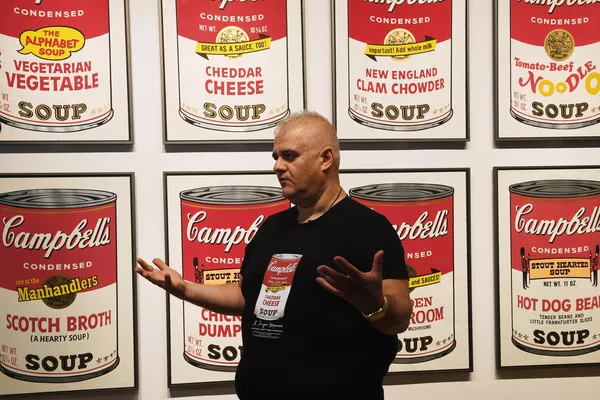 Warhol empezó a dedicarse a la pintura a finales de los años 50 y se alzó a la fama en 1962 cuando realizó una exhibición con sus pinturas de latas de sopa Campbell y botellas de Coca-Cola, los cuales consideraba iconos de la cultura estadounidense.En la foto: el productor de la exposición Yo, Andy Warhol en la Galería Estatal Tretiakov (Rusia) habla acerca del trabajo del artista. - Sputnik Mundo