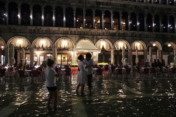 Una pareja baila en la plaza inundada. - Sputnik Mundo