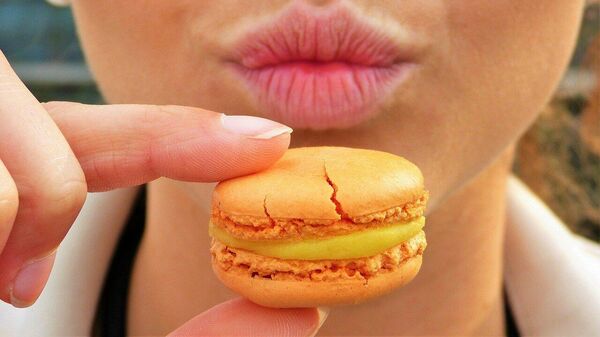 Una mujer con un macaron  - Sputnik Mundo