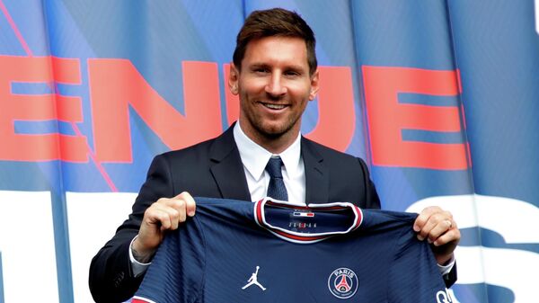 Leo Messi sostiene una camiseta del PSG - Sputnik Mundo