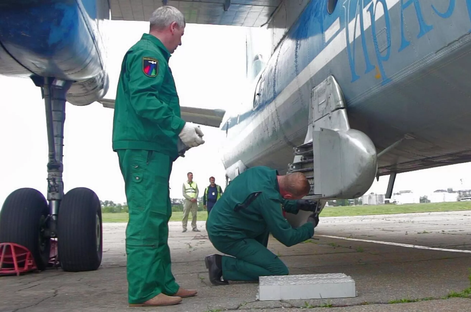 Unos trabajadores instalan cartuchos de yoduro de plata en el avión An-26 Tsiklon Unos trabajadores instalan cartuchos de yoduro de plata en el avión An-26 Tsiklon - Sputnik Mundo, 1920, 15.08.2021