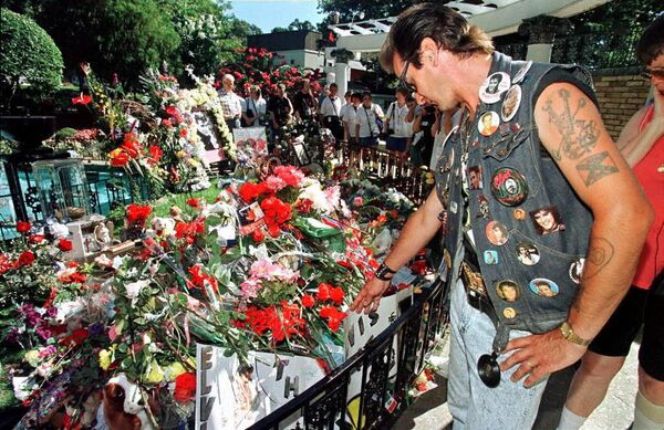 Sin embargo, todo indicaba que Presley no tenía ganas de morir. El cantante estaba a punto de iniciar una gira, su nuevo álbum acababa de salir a la venta y, además, se preparaba para casarse con la actriz Ginger Aldean.En la foto: un fanático de Elvis visita su tumba en el día del 20 aniversario de su muerte, en 1997. - Sputnik Mundo