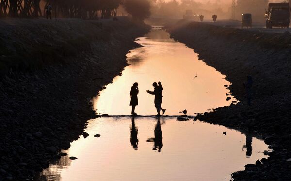 No obstante, a pesar de la aparente falta de atractivo de este país para los invasores, todos los grandes imperios, empezando por el de Alejandro Magno, intentaron conquistarlo.En la foto: niños afganos atraviesan un canal en la periferia de Jalalabad. - Sputnik Mundo