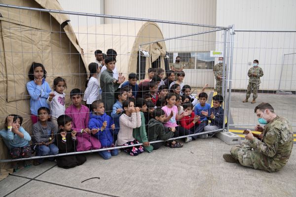 Un soldado estadounidense toca la guitarra ante un grupo de menores afganos refugiados en la base estadounidense de Rammstein (Alemania). - Sputnik Mundo