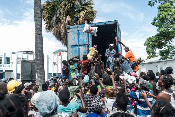 Trabajadores humanitarios reparten alimentos a los vecinos de la localidad de Les Cayes (Haití). - Sputnik Mundo