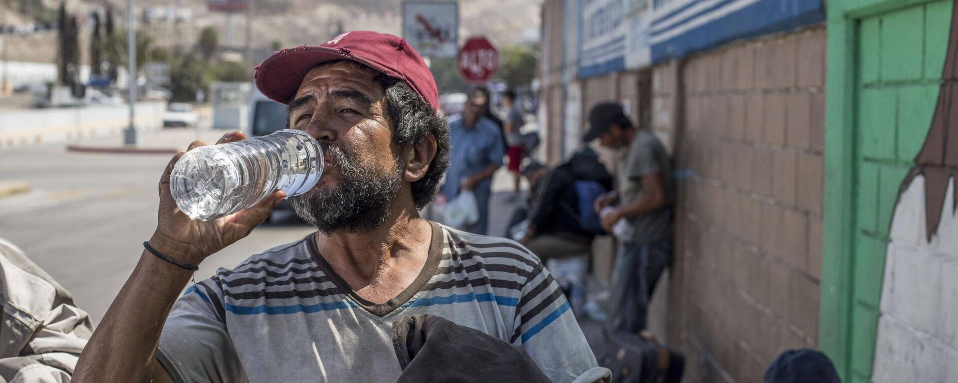 Un hombre toma agua (imagen referencial) - Sputnik Mundo, 1920, 27.08.2021