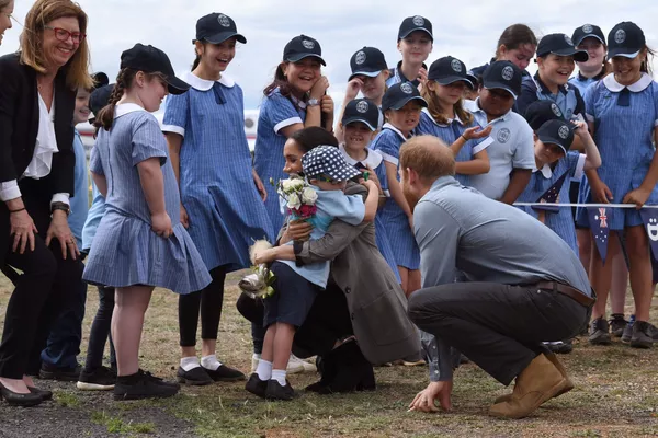 El uniforme escolar en Australia es similar al uniforme escolar británico tradicional, pero es más abierto y ligero, y con un tocado.En la foto: escolares australianos con el príncipe Harry y su esposa Meghan en el aeropuerto de Dubbo, 2018. El uniforme escolar en Australia es similar al uniforme escolar británico tradicional, pero es más abierto y ligero, y con un tocado.En la foto: escolares australianos con el príncipe Harry y su esposa Meghan en el aeropuerto de Dubbo, 2018. - Sputnik Mundo