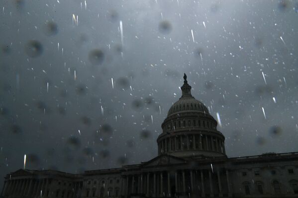 Los fuertes vientos también derribaron torres de alta tensión y  árboles, y provocó la explosión de varios transformadores.En la foto: la lluvia torrencial en Washington DC. - Sputnik Mundo