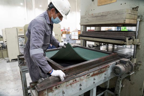 Allí ya han comenzado a procesarlos para fabricar suelos.En la foto: un trabajador de la planta de Salmi revisa un suelo de goma fabricado a partir de neumáticos reciclados. Allí ya han comenzado a procesarlos para fabricar suelos.En la foto: un trabajador de la planta de Salmi revisa un suelo de goma fabricado a partir de neumáticos reciclados. - Sputnik Mundo