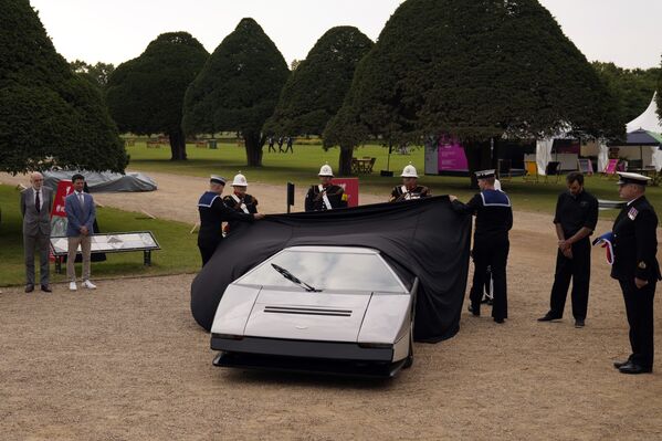 El trabajo de restauración duró 18 meses.En la foto: dos cadetas de la Armada Real del Reino Unido quitan el velo del Aston Martin Bulldog, mostrando al público el auto que fue restaurado tras estar en el olvido durante 35 años. - Sputnik Mundo