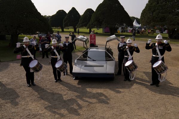 A pesar de su imponente motor, la falta de tecnologías modernas se hace evidente al observar la aceleración del Bulldog: para llegar de 0 a 100 km/h le hacen falta 5,1 segundos. A modo de comparación, el Tesla Model S Plaid necesita poco más de 2 segundos.En la foto: los tamborileros de la Orquesta Real de la Armada del Reino Unido posan para las fotos después de la presentación del Aston Martin Bulldog restaurado.   - Sputnik Mundo