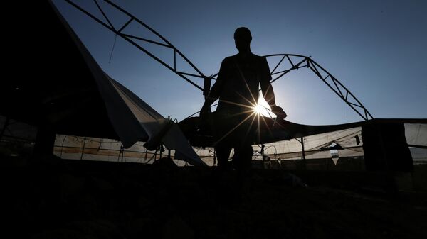 Un palestino inspecciona el lugar de un ataque aéreo israelí tras el lanzamiento de cohetes palestinos contra Israel, en el sur de la Franja de Gaza, el 12 de septiembre de 2021 - Sputnik Mundo