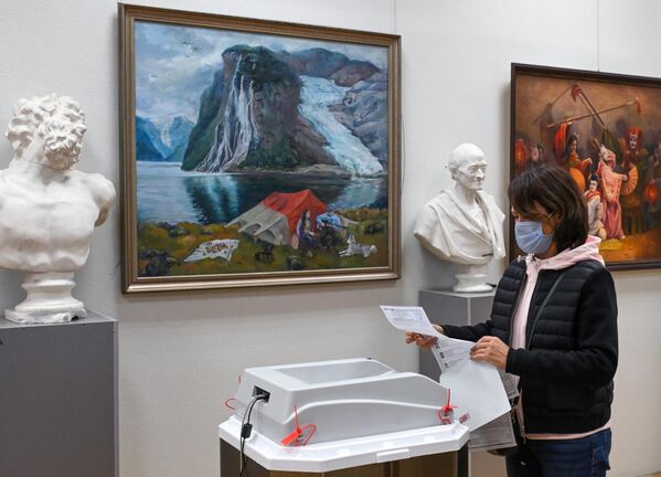 Una mujer vota en un colegio electoral habilitado en el Instituto Pedagógico de Moscú. - Sputnik Mundo