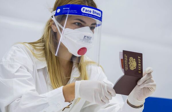 Trabajadora de uno de los colegios electorales revisa el documento de identidad de un votante. - Sputnik Mundo