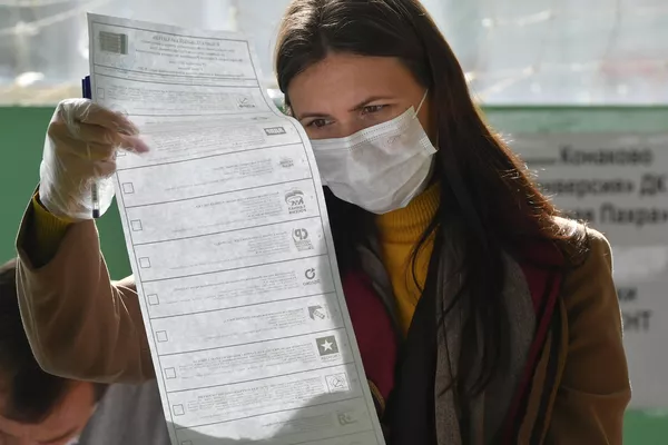 Una mujer busca su candidato en la papeleta electoral. Una mujer busca su candidato en la papeleta electoral. - Sputnik Mundo