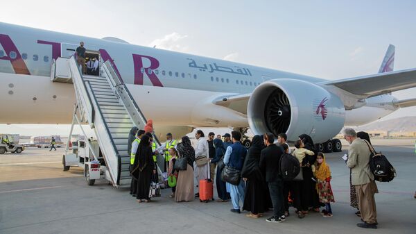 Pasajeros afganos frente a un avión en el Aeropuerto Internacional de Kabul, Afganistán, el 19 de septiembre de 2021 - Sputnik Mundo