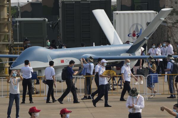 El salón aeronáutico recibió su nombre por la ciudad en que se celebra: Zhuhai, en la provincia sureña china de Guangdong.En la foto: unos visitantes pasan al lado del dron chino CH-4. - Sputnik Mundo