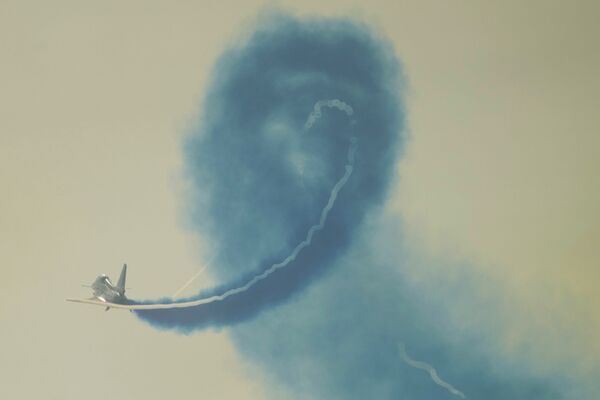 Un miembro del grupo acrobático 1 de Agosto, de la FFAA china, realiza un vuelo de demostración en un caza J-10 en el Salón Aeroespacial de Zhuhai. - Sputnik Mundo