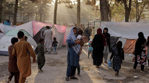 Familias afganas desplazadas, que huyen de la violencia en sus provincias, cerca de tiendas de campaña en el parque Shahr-e Naw, en Kabul, Afganistán, 4 de octubre de 2021 - Sputnik Mundo