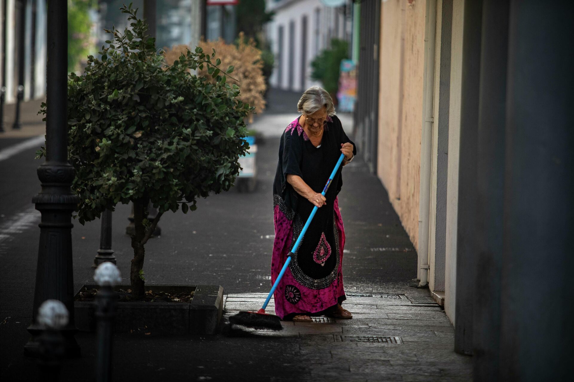 Una mujer barre la ceniza caída en los Llanos de Aridane (La Palma) - Sputnik Mundo, 1920, 05.10.2021
