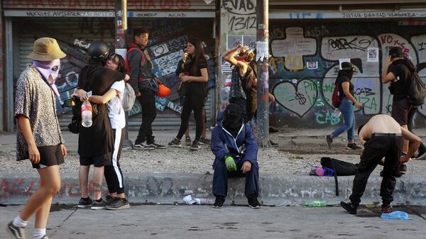 Distintos manifestantes en la Alameda de Santiago de Chile durante el estallido social de 2019 - Sputnik Mundo