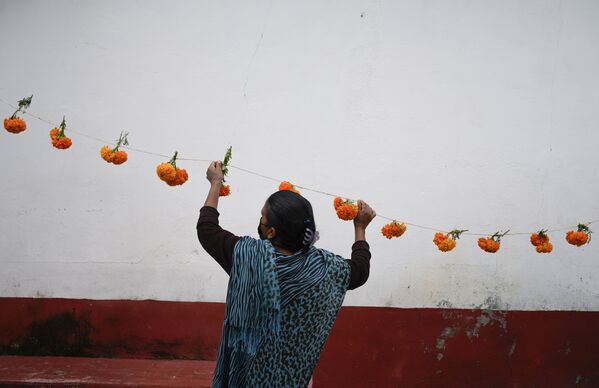 Una guirnalda de flores de cempasúchil, las flores tradicionales utilizadas para decorar casas y tumbas en el Día de Muertos. Se cree que su aroma guía a las almas que regresan a la tierra en este día y las hace sentirse felices. - Sputnik Mundo