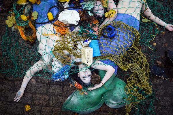 Activistas de Ocean Rebellion durante una actuación para protestar contra el uso de la pesca de arrastre de fondo en Glasgow (Escocia), antes de la inauguración de la 26ª conferencia de las Naciones Unidas sobre el cambio climático celebrada en esa ciudad el 30 de octubre de 2021. - Sputnik Mundo