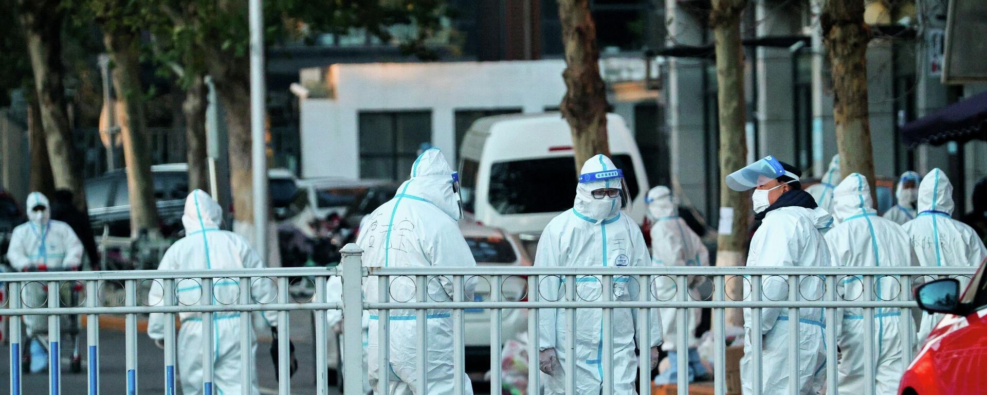 El personal de seguridad con trajes protectores custodia el perímetro de un complejo residencial cerrado tras un brote local del coronavirus en Pekín, China, el 11 de noviembre de 2021 El personal de seguridad con trajes protectores custodia el perímetro de un complejo residencial cerrado tras un brote local del coronavirus en Pekín, China, el 11 de noviembre de 2021 - Sputnik Mundo, 1920, 15.11.2021