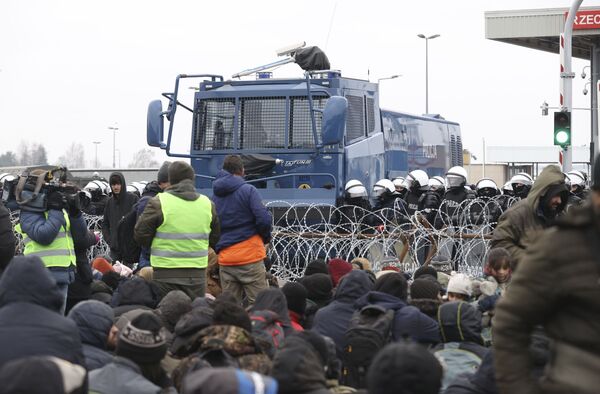 Más tarde se supo que un helicóptero polaco empezó a sobrevolar la multitud de migrantes, lo que obligó a los refugiados a detenerse. - Sputnik Mundo