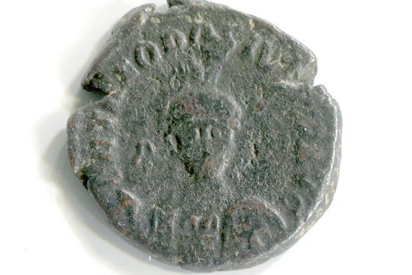 La moneda con el retrato de Teodosio II acuñada en los años 401-403 en la ciudad de Antioquía, en el anverso se puede ver el perfil del emperador, en el reverso la ciudad de Constantinopla representada por un ser humano sentado en un trono que se apoya con su pie en un barco y mantiene en sus manos un cetro, y a la derecha hay una figura de la Diosa de Victoria que planea con una corona.   - Sputnik Mundo