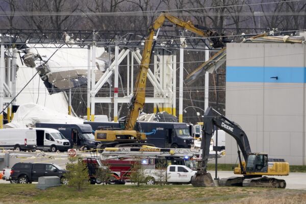 Equipos de rescate con maquinaria realizan la retirada de escombros de un almacén de Amazon dañado por el tornado en Edwardsville, Illinois. - Sputnik Mundo