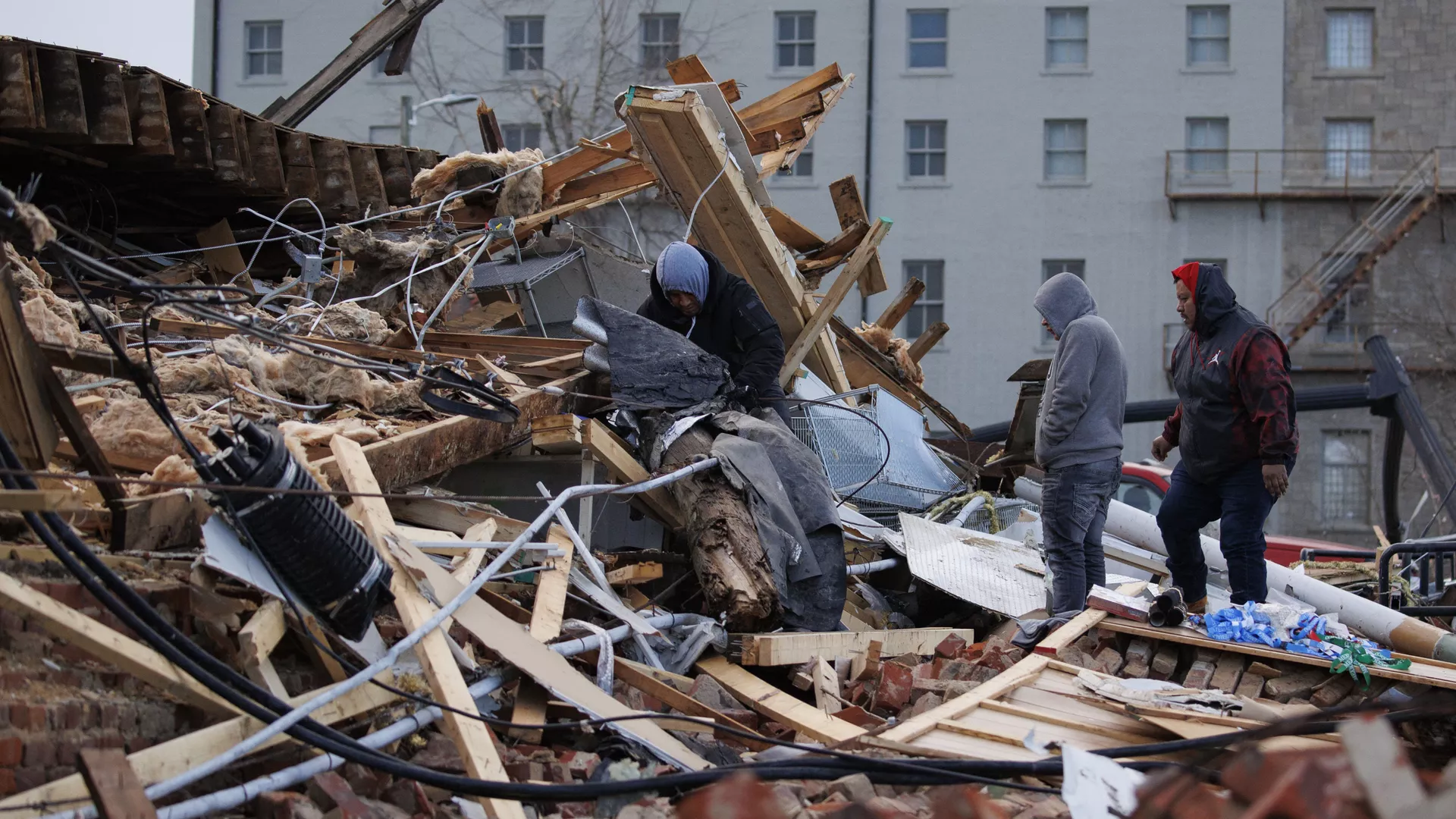 People search through a tornado-damaged building on December 11, 2021 in Mayfield, Kentucky