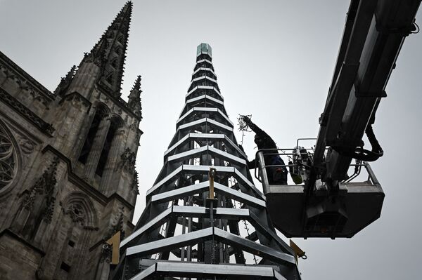 La instalación de un árbol de Navidad de 11 metros hecho de acero y de vidrio reciclado en Burdeos, Francia. Este árbol de Navidad, de presupuesto modesto para la urbe, se instalará durante otros cuatro años en la plaza Pey-Berlan, frente a la catedral de Saint-André, justo enfrente del Ayuntamiento. - Sputnik Mundo