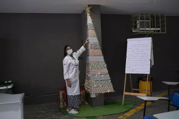 Un sanitario en un árbol de Navidad hecho con frascos de vacunas contra la gripe y el COVID-19 en el Centro Médico Ernani Agrícola de Río de Janeiro (Brasil). El objetivo de este árbol de Navidad es recordar a los habitantes de la ciudad que se han de vacunar. Un sanitario en un árbol de Navidad hecho con frascos de vacunas contra la gripe y el COVID-19 en el Centro Médico Ernani Agrícola de Río de Janeiro (Brasil). El objetivo de este árbol de Navidad es recordar a los habitantes de la ciudad que se han de vacunar. - Sputnik Mundo